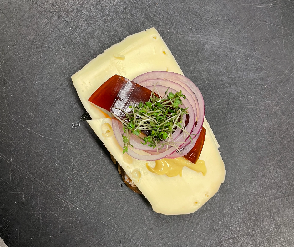 Mellemlagret ostemad med løg og sennep på rugbrød